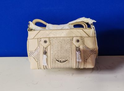 un sac à main blanc posé sur une table près d'un mur bleu
