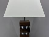 une lampe de table en bois surmontée d'un abat-jour blanc
