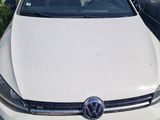 the white car is parked in the grass next to other cars