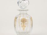 clear glass perfume bottle with a gold design on the top