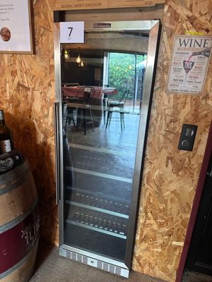 une cave à vin posée à côté d'un tonneau de vin dans une pièce