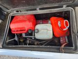 two red and white gas cans in the trunk of a car