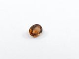 a close up view of a faceted citrine stone on a white surface
