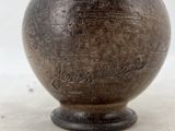 a brown vase sitting on a table with a white background