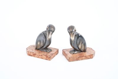pair of black and silver figurines of a bird on a stone base