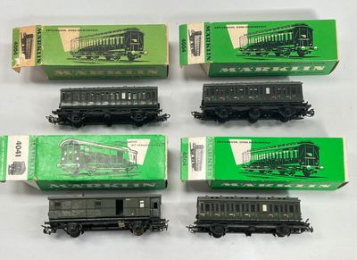 six trains miniatures dans leurs boîtes sont alignés sur une surface blanche