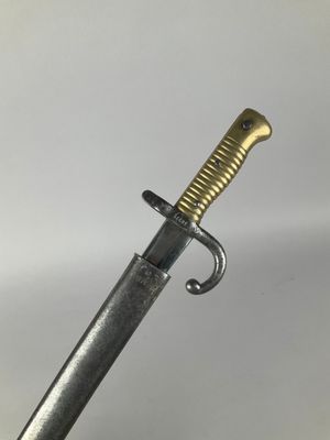 a close up of a sword on a white surface