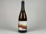La bouteille de bière est posée sur la table, sur un fond blanc.
