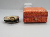 une petite boîte et une petite pièce de monnaie posées sur une table