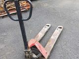 a pallet that is sitting on the ground in front of a pile of wood