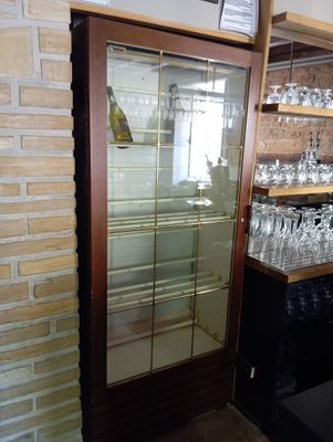 a glass case with wine glasses on it in a store