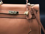 a brown leather handbag on a black background