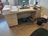a desk with a computer, keyboard, mouse, and papers on it