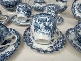 many blue and white tea cups and saucers on the table