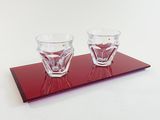 two shot glasses sitting on a tray on a table