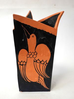 a black and orange vase with a bird on it