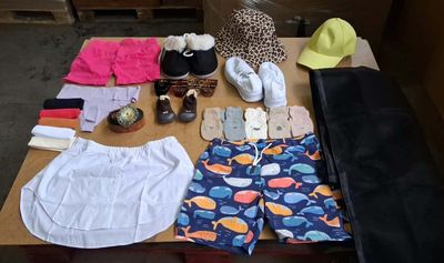une table sur laquelle sont posés de nombreux vêtements et chaussures