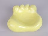 a yellow toothbrush holder on a white surface
