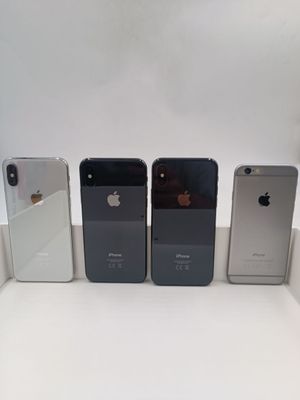 Quatre iPhones sont alignés les uns à côté des autres sur une surface blanche