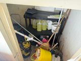 a yellow bucket sitting in the corner of a room next to a shelf
