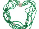 un gros plan d'un collier de perles vertes sur fond blanc