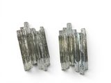two pieces of silver colored quartz on a white surface