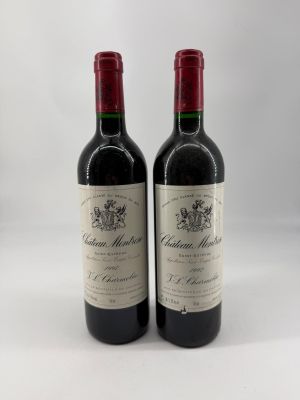 deux bouteilles de vin rouge posées l'une à côté de l'autre sur une surface blanche