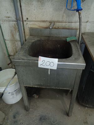 a dirty sink in a dirty room with a price tag on it