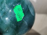 a green ball with a sticker on it sitting on a table