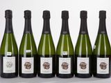 six bouteilles de vin sont alignées sur une table