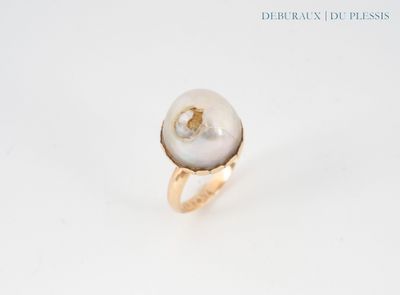 an image of a white pearl and gold ring on a white surface