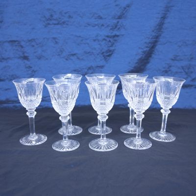 six verres à pied en verre transparent sont alignés sur une table