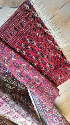 une pile de tapis orientaux posée sur un parquet