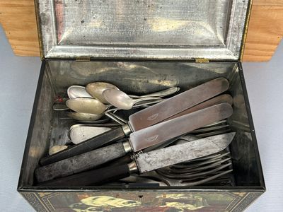 des couverts rangés dans une boîte en métal, contenant des cuillères et des cuillères