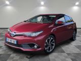 a red toyota auris hybrid parked in a garage