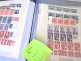 un livre ouvert posé sur une table, à côté d'une pile de timbres