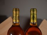 two bottles of wine sitting next to each other on a table