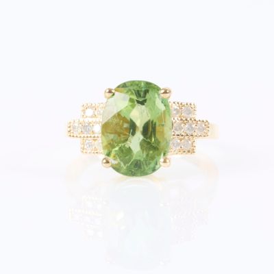 an oval green tourmaline and diamond ring in yellow gold