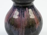 a black and purple vase sitting on a white surface