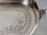 an antique silver plate with a decorative design on it