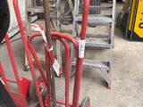a red hand truck with a broom and a broom on it
