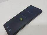 the back of a black phone sitting on top of a white table
