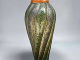 an image of a green and orange vase sitting on a white surface