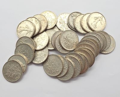 tas de pièces d'argent sur une surface blanche