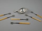 une cuillère, une fourchette et un repose-cuillère en argent posés sur une table