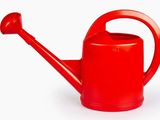 red watering can on a white background