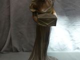 statue en bronze représentant une femme tenant un sac à main, posée sur un socle