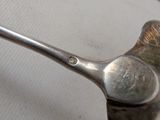a silver spoon with a metal handle on a white surface