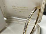 a close up of a gold ring with diamonds in a box