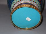 a blue vase with a gold rim sitting on a table